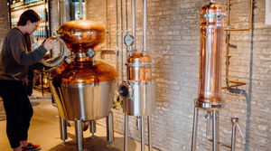 Lead distiller at In The Welsh Wind Distillery working with one of the copper pot stills which is used to create our distinctive Welsh spirits in small batches.