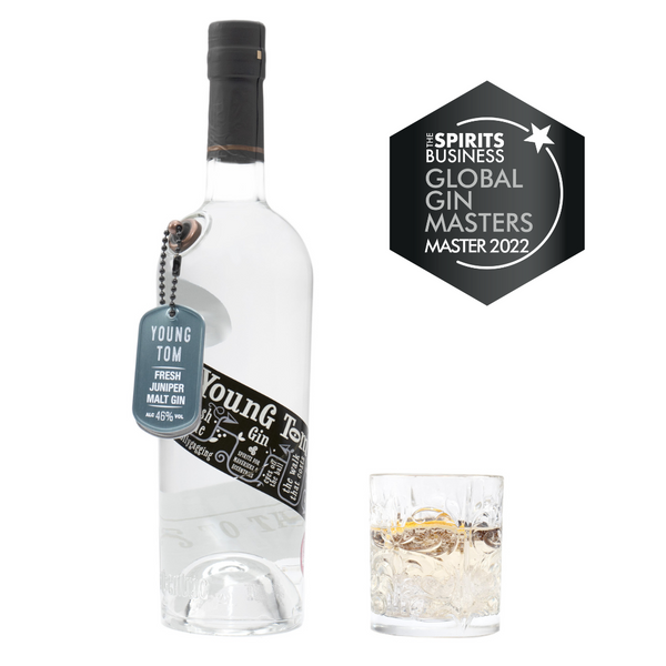 A 70cl bottle of Eccentric Spirit Co's Young Tom Gin alongside an old fashioned glass half-filled with the Welsh gin. A Master Medal is displayed in the corner which was awarded to this Welsh gin at the Global Gin Masters 2022.